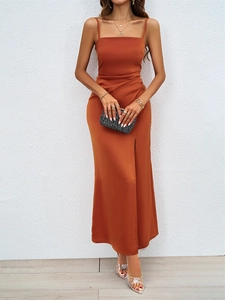 Détail de la robe longue en satin caramel montrant la fente et les plis à la taille
