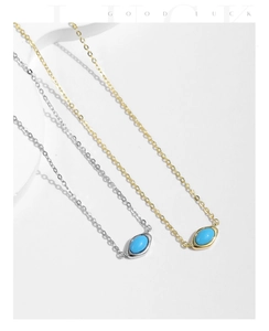 Macro shot of minimalist silver and gold chain necklaces with turquoise oval pendants