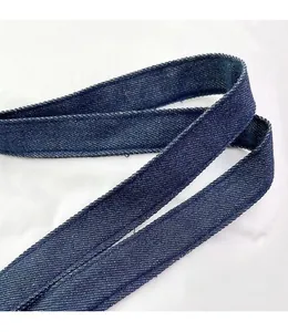 Detail of reinforced denim tote handle with premium stitching and navy blue texture