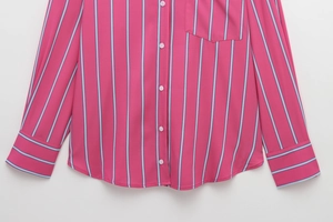 Detailed view of pink and blue vertical striped shirt with chest pocket and white buttons
