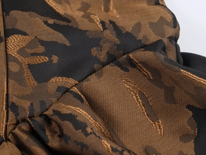 Gros plan sur un tissu jacquard noir et or avec motifs de feuilles et textures