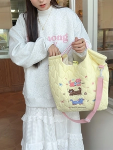 Quilted cotton tote bag with cartoon cat embroidery and adjustable pink strap on model