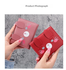 Close-up of pink and red cartoon rabbit ears purses in textured faux leather finish