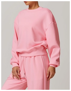 Détail de l'ourlet du sweat rose et du pantalon de jogging à cordon assorti