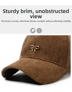 Detailed close-up of brown herringbone fabric and golden metal bow on the stylish baseball cap