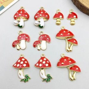 Macro detail of red and white mushroom alloy charms with gold plating for DIY jewelry
