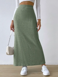 Detail of elegant sage green ribbed knit maxi skirt featuring high waist and side slit detail
