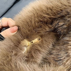 Detailed macro view of the fluffy faux fur handbag texture with golden zipper closure