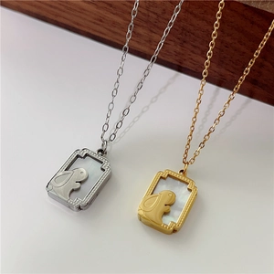 Detail of gold and silver rabbit pendants with white mother of pearl inlay on square charms