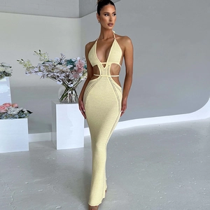 Dettaglio dell'abito lungo in maglia gialla con eleganti ritagli sulla vita aderente