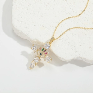 Collier croix dorée avec œil protecteur et zircons colorés sur une pierre blanche