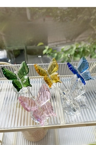Macro detail of multi-faceted crystal butterflies in pink, blue, yellow, and green