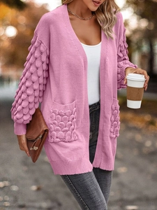 Detail of pink knit cardigan showing unique 3D fish scale texture on sleeves and pocket