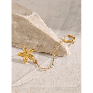 18k gold plated starfish chain ear cuff with sparkling zircon accents on stone background