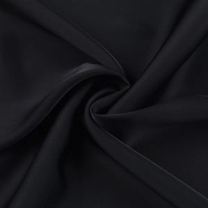 Gros plan sur la dentelle noire montrant le drapé fluide et la texture délicate du tissu