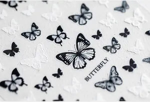 Macro detail of 5D embossed butterfly nail art stickers with black and white retro patterns