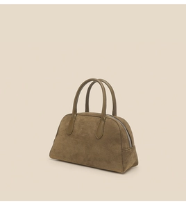 Detail of olive green suede bowling bag with smooth leather handles and silver zipper