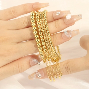 Minimalist gold beaded bracelet set with four different bead sizes and adjustable chains