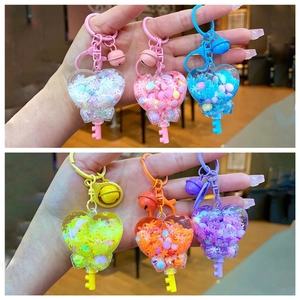 Set of six colorful heart-shaped liquid quicksand keychains with bells and key charms
