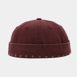Détail du bonnet docker bordeaux montrant la texture délavée et les bords effilochés