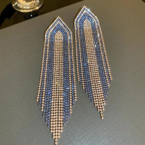 Detailed macro view of champagne and blue rhinestone leaf tassel drop earrings