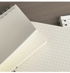 Close-up of spiral bound notebooks with high-quality grid and blank cream paper pages