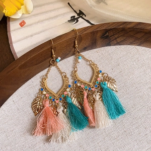 Detail of bohemian floral tassel earrings with colorful beads and metal leaf pendants