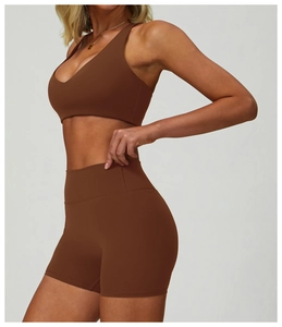 Detail view of high-waist fitness shorts and V-neck sports bra in dark brown coffee color