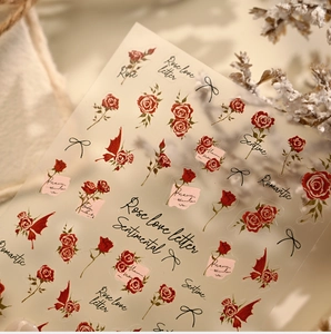 Detail of vintage red rose nail stickers with butterfly bows and artistic scripts