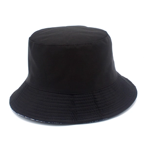 Detail of a black cotton bucket hat showing fabric texture and neat stitching on white background