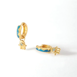Detail view of golden Hamsa Hand hoop earrings with blue enamel wavy pattern and crystal inlay