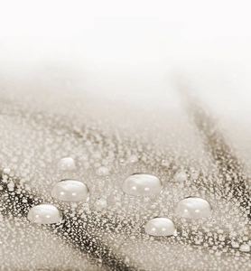 Macro shot of waterproof fabric texture showing spherical water beads on clear umbrella