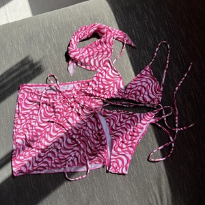 Pink wavy pattern 4-piece bikini set with matching sarong skirt and headscarf detail