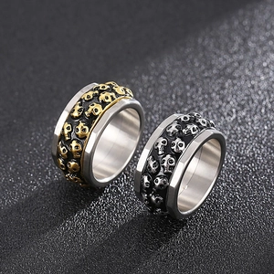 Macro detail of rotating double row skull rings in silver gold and black steel
