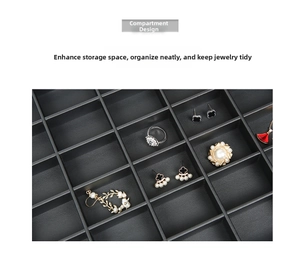 Macro detail of black PU multi-grid jewelry tray showcasing rings, earrings and pins