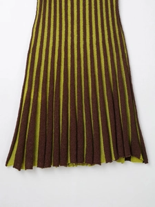 Detailed view of the vertical pleated knit texture and colorful striped hem of the dress