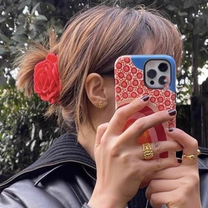Elegante molletta per capelli rosa rossa e gioielli dorati con giacca di pelle
