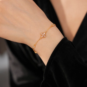 Macro shot of gold floral bracelet with zircon stones on a black velvet background