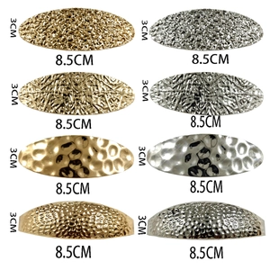 Détail des barrettes ovales en métal de 8,5cm en finitions dorées et argentées texturées
