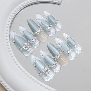 Glacial blue cat eye stiletto press-on nails with white lace, pearls, and crystals
