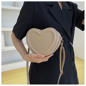 Dettaglio della borsa a tracolla kaki a forma di cuore con la scritta Fashion & Bag