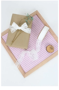 Detail of white hollow lace ribbon for gift wrapping with delicate crochet texture