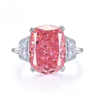 Macro view of cushion-cut pink gemstone ring with step-cut side diamonds and silver band