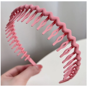 Detail of pink wavy non-slip hairband with teeth for washing face in matte finish