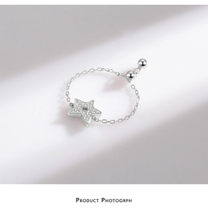 Macro detail of S925 silver star ring with micro-pave crystals and adjustable chain band