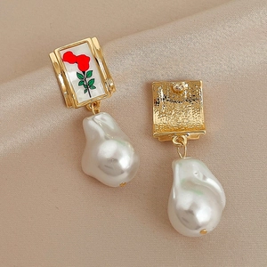 Vintage floral pearl drop earrings with gold metal and red rose pattern on silk backdrop