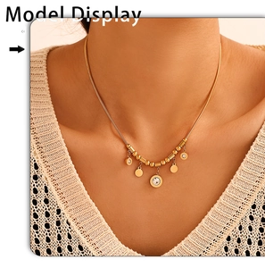 Close-up of golden Roman tassel necklace with zircon charms on a delicate snake chain