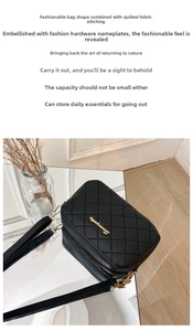 Detail of black quilted crossbody bag with gold hardware and elegant metal logo plate