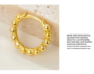 Close-up of gold beaded hoop earring with S925 hallmark on polished sterling silver