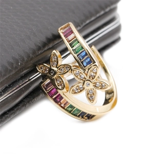 Detailed close-up of a floral ring with pavé zircons and colorful gemstones on gold band